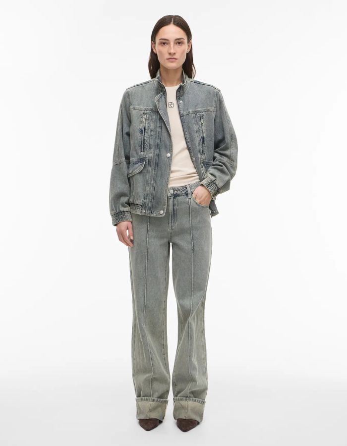 Femme portant un jean Vivian denim bleu clair coupe regular, taille mi-haute, avec une veste en jean assortie.