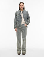 Femme portant un jean Vivian denim bleu clair coupe regular, taille mi-haute, avec une veste en jean assortie.