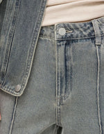 Jean Vivian en denim bleu clair délavé, coupe regular, taille mi-haute, avec braguette zippée et bouton argenté.