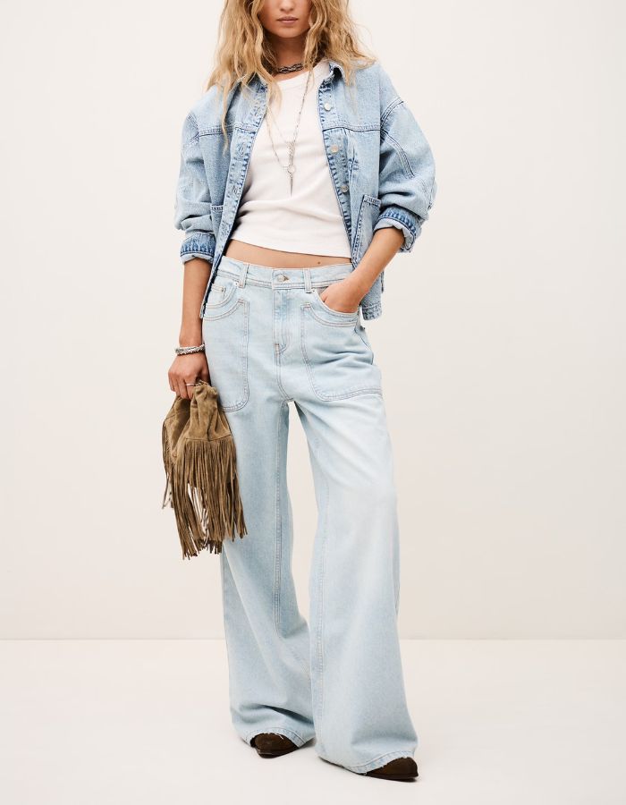 Femme portant un jean Zoel Bleachblue ba&sh cargo en coton biologique, coupe large, avec poches plaquées.