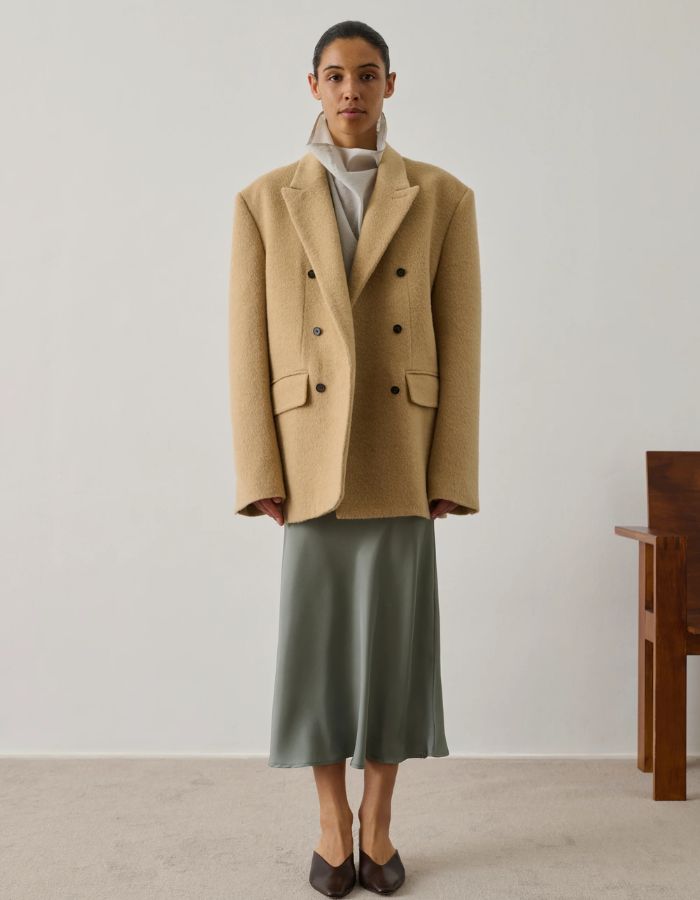 Mannequin portant une jupe Fever Vert d'Eau mi-longue en sergé fluide avec un blazer beige.