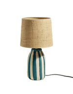 Lampe Palmaria bleu Sarah Lavoine avec pied en céramique rayé bleu et blanc, abat-jour en rabane naturelle.
