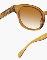 Gros plan des Lunettes de soleil unisexes IZIPIZI modèle #C de forme carrée vintage épaisse. La monture brillante arbore une couleur miel ocre ambrée et translucide nommée Golden Canyon, associée à des verres solaires polarisés protecteurs.