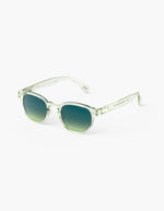 Côté des Lunettes de soleil unisexes IZIPIZI modèle #C de forme carrée vintage épaisse. La monture brillante est d'un coloris vert doux et légèrement translucide nommé Green Fields, associée à des verres solaires polarisés protecteurs