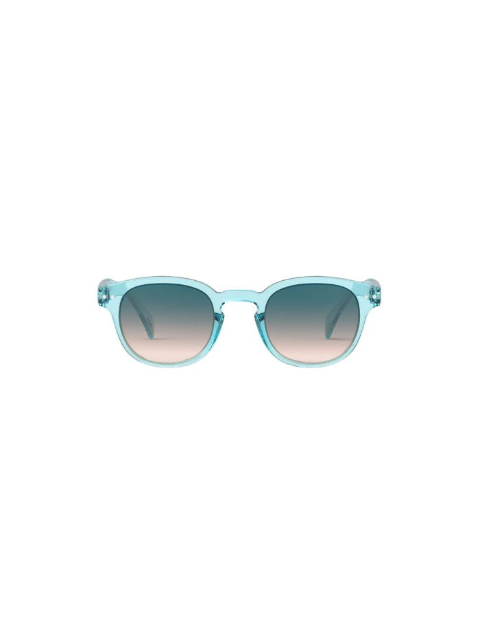 Lunettes de soleil unisexes IZIPIZI modèle #C de forme carrée vintage épaisse. La monture brillante est d'une couleur bleu turquoise translucide inspirée de la pierre turquoise, associée à des verres solaires bleus.