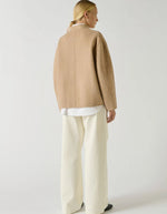 Dos du Manteau court pour femme en laine double face beige chiné, modèle Windsor de la marque SOEUR. Présente une coupe ample au volume rond, un col asymétrique, une patte de boutonnage semi-cachée et deux grandes poches plaquées sur le devant.