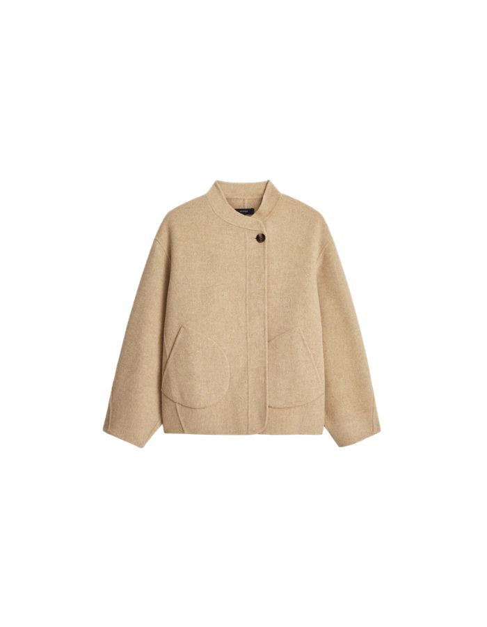 Manteau court pour femme en laine double face beige chiné, modèle Windsor de la marque SOEUR. Présente une coupe ample au volume rond, un col asymétrique, une patte de boutonnage semi-cachée et deux grandes poches plaquées sur le devant.