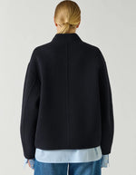 Dos du Manteau court pour femme en laine double face bleu marine profond Deep Navy, modèle Windsor de la marque SOEUR. Présente une coupe ample au volume rond, un col asymétrique, une patte de boutonnage semi-cachée et deux grandes poches plaquées sur le devant.