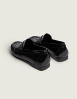 Talon des Mocassins en cuir noir brillant pour homme et femme de type Penny Loafers, modèle Wrinkle de la marque POSA. Chaussures basses en cuir italien box poli avec une bride classique sur le coup de pied, un bout arrondi à empiècement plissé texturé et une semelle noire fine.