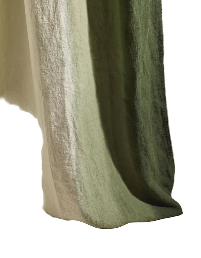 Détail de la Grande nappe rectangulaire Dip Dye Forêt par Maison Sarah Lavoine. 100% lin lavé avec dégradé de vert artisanal teinté par immersion. Dimensions 300x175 cm, usage polyvalent nappe ou rideau.