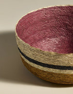 Détail de finitions du Grand panier rond Globe par Maison Sarah Lavoine. Tressage artisanal en fibres de palmier avec rayures horizontales Ocre et Carmin, fabriqué au Mexique, dimensions H9 x Ø25 cm