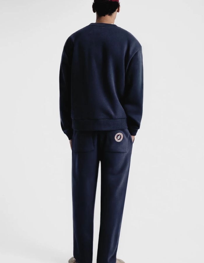 Silhouette de dos avec le Pantalon de jogging ajusté coupe droite pour homme et femme en molleton bleu nuit 350g avec cordon beige et patch logo dos, modèle Iconic Straight couleur Night de Sweet Pants.
