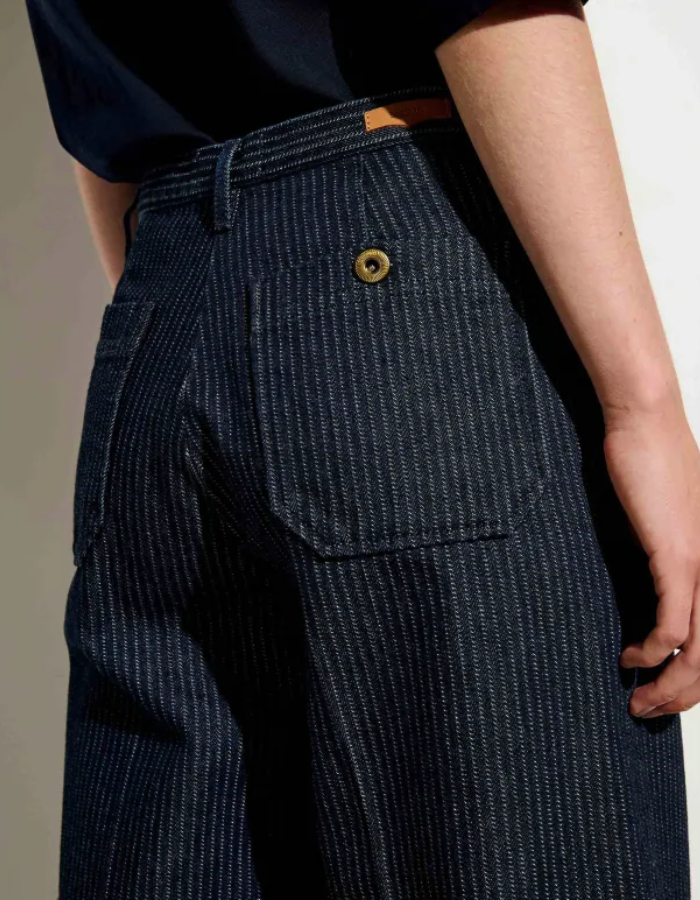 Bassin du Pantalon droit taille haute pour femme en denim bleu indigo à fines rayures coutil avec plis marqués le long de la jambe, modèle Pantalon Aldricks couleur Blootil de la marque Sessùn.
