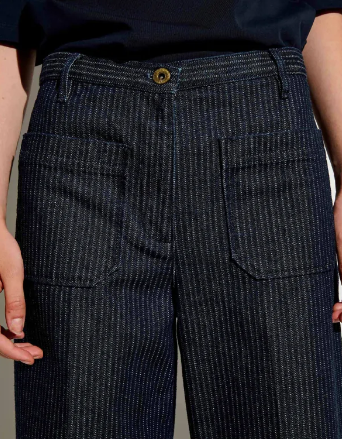 Ceinture du Pantalon droit taille haute pour femme en denim bleu indigo à fines rayures coutil avec plis marqués le long de la jambe, modèle Pantalon Aldricks couleur Blootil de la marque Sessùn.