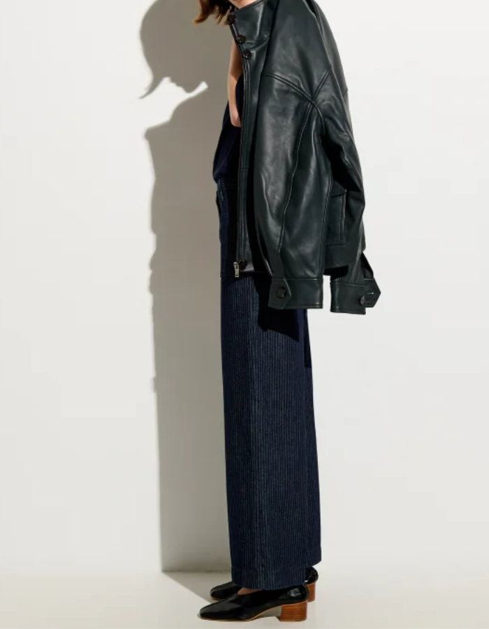 Profil du Pantalon droit taille haute pour femme en denim bleu indigo à fines rayures coutil avec plis marqués le long de la jambe, modèle Pantalon Aldricks couleur Blootil de la marque Sessùn.