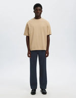 Silhouette avec le Pantalon droit pour homme de couleur bleu marine foncé Dark Sapphire, modèle Straight Robert String Pant de la marque Selected. Présente une coupe droite contemporaine, des poches latérales, et une ceinture hybride élastiquée ajustable à l'aide d'un cordon de serrage noir et d'une fermeture par bouton.
