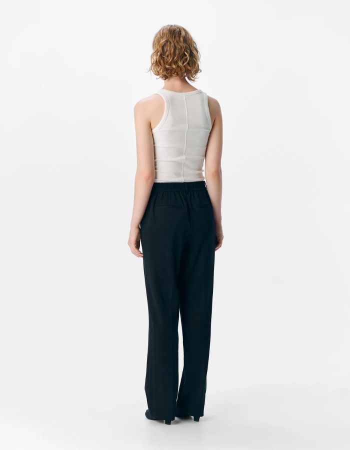 Vue de dos du Pantalon de tailleur coupe droite à taille mi-haute pour femme, modèle Lisa de la marque Object. Tissu tissé robuste et élégant de couleur noire unie avec des poches latérales invisibles.