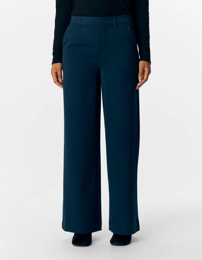 Devant du Pantalon large pour femme de couleur bleu marine foncé Sky Captain, modèle Lisa Wide Pant de la marque Object. Présente une coupe droite très ample de style wide-leg, une taille mi-haute froncée par un élastique confortable et des poches discrètes insérées dans les coutures latérales.