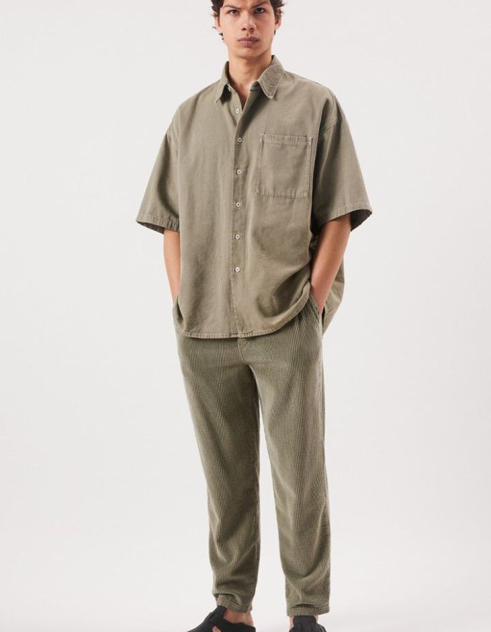 Silhouette avec le Pantalon en velours côtelé pour homme de couleur beige argile clair Argile Vintage, modèle Padow de la marque American Vintage. Présente une coupe droite ample d'inspiration jogging avec une taille élastiquée dotée d'un lien de resserrage et des poches italiennes.