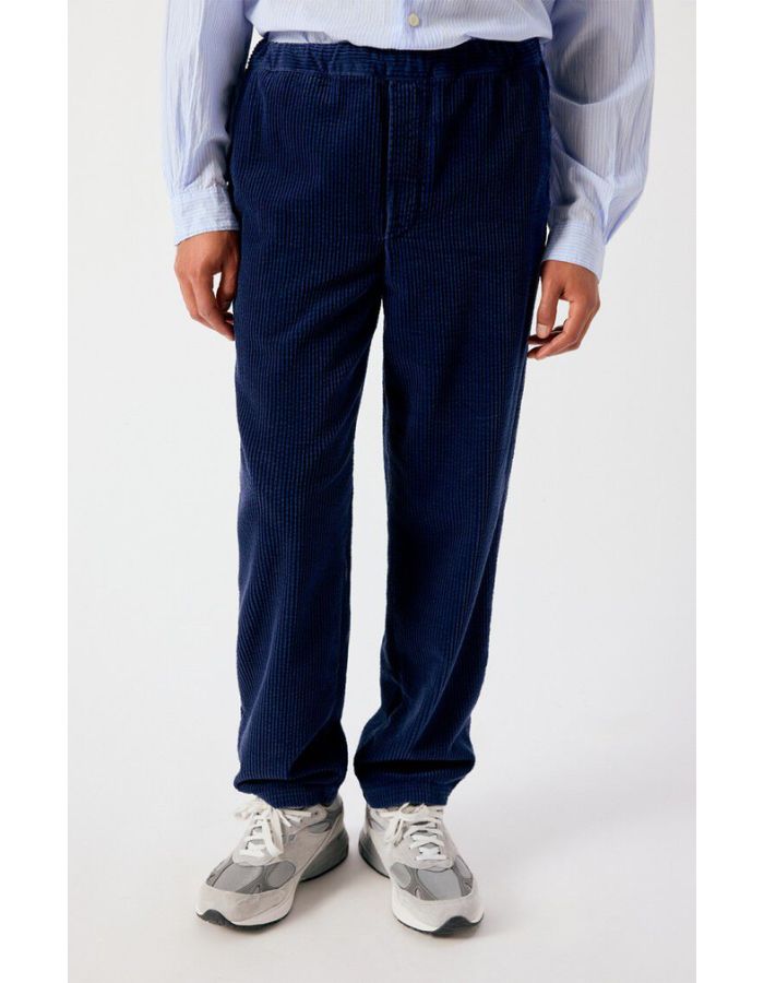 Vue de face du Pantalon en velours côtelé pour homme de couleur bleu marine foncé Navy Vintage, modèle Padow de la marque American Vintage. Présente une coupe droite ample d'inspiration jogging avec une taille élastiquée dotée d'un lien de resserrage et des poches italiennes.