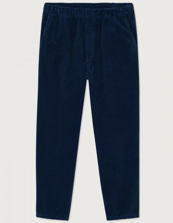 Pantalon en velours côtelé pour homme de couleur bleu marine foncé Navy Vintage, modèle Padow de la marque American Vintage. Présente une coupe droite ample d'inspiration jogging avec une taille élastiquée dotée d'un lien de resserrage et des poches italiennes.