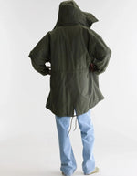 Dos de la Parka longue oversize pour homme couleur vert olive foncé avec capuche, fermeture zippée sous pression et poches en biais, modèle Jinx de la marque Bellerose.