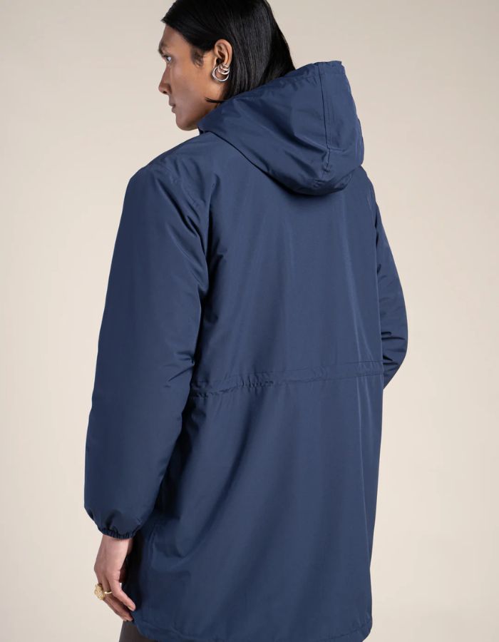 Dos de la Parka imperméable mixte bleu indigo pour homme et femme, modèle Pompidou de la marque Flotte. Présente une coupe ajustée avec cordon de serrage à la taille, fermetures zippées étanches et doublure en polaire chaude.