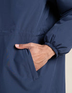 Poche de la Parka imperméable mixte bleu indigo pour homme et femme, modèle Pompidou de la marque Flotte. Présente une coupe ajustée avec cordon de serrage à la taille, fermetures zippées étanches et doublure en polaire chaude.