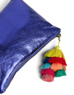 Pompom de la Pochette de soirée rectangulaire pour femme en tissu de couleur bleu éclatant. Fermée par un zip sur le dessus, elle est ornée d'un grand pompon suspendu composé de franges colorées superposées en dégradé multicolore
