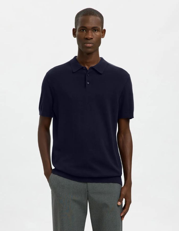Homme portant un polo Navy Berg en maille plate, manches courtes, col polo boutonné et coupe regular.