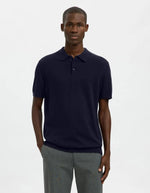 Homme portant un polo Navy Berg en maille plate, manches courtes, col polo boutonné et coupe regular.
