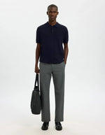 Homme portant un polo Navy Berg en maille plate avec manches courtes et poignets côtelés, coupe regular.