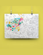 Poster géant à colorier Dinos OMY, 70x100 cm, avec des dinosaures, volcans et détails humoristiques, partiellement colorié.
