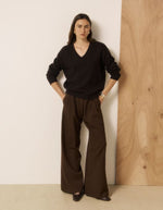 Silhouette avec le Pull ample col V pour femme en laine et cachemire marron, modèle Milanto de la marque HARTFORD. Présente des emmanchures souples et des finitions en bord-côte au col, aux poignets et à la base.