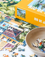 Détail du puzzle 1000 pièces Rio de Janeiro de la marque Piecely. L'illustration colorée montre le Christ Rédempteur, les collines tropicales et la baie de Rio dans un style graphique moderne et chaleureux