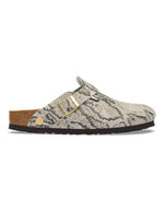 Profil des Sabots fermés modèle Boston de la marque Birkenstock pour femme. La tige est en cuir velours souple beige clair avec un motif effet peau de serpent (Snake Oyster), dotée d'une bride réglable avec boucle métallique et montée sur une semelle anatomique en liège.