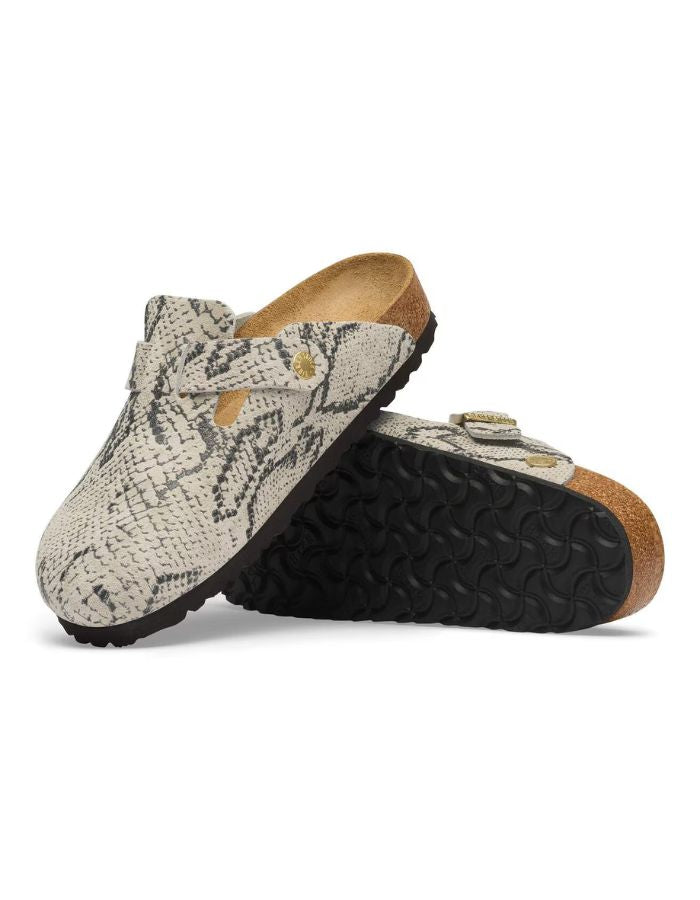 Semelles des Sabots fermés modèle Boston de la marque Birkenstock pour femme. La tige est en cuir velours souple beige clair avec un motif effet peau de serpent (Snake Oyster), dotée d'une bride réglable avec boucle métallique et montée sur une semelle anatomique en liège.