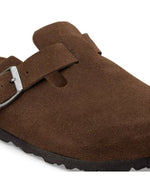 Boucle des Sabots fermés modèle Boston de la marque Birkenstock en cuir velours souple de couleur marron foncé Carafe. Présente une bride ajustable à boucle métallique sur le dessus et une semelle anatomique ton sur ton en liège avec lit de pied souple, version chaussant étroit.