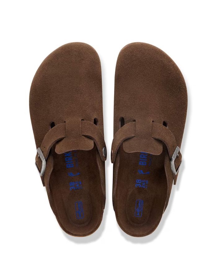 Dessus des Sabots fermés modèle Boston de la marque Birkenstock en cuir velours souple de couleur marron foncé Carafe. Présente une bride ajustable à boucle métallique sur le dessus et une semelle anatomique ton sur ton en liège avec lit de pied souple, version chaussant étroit.
