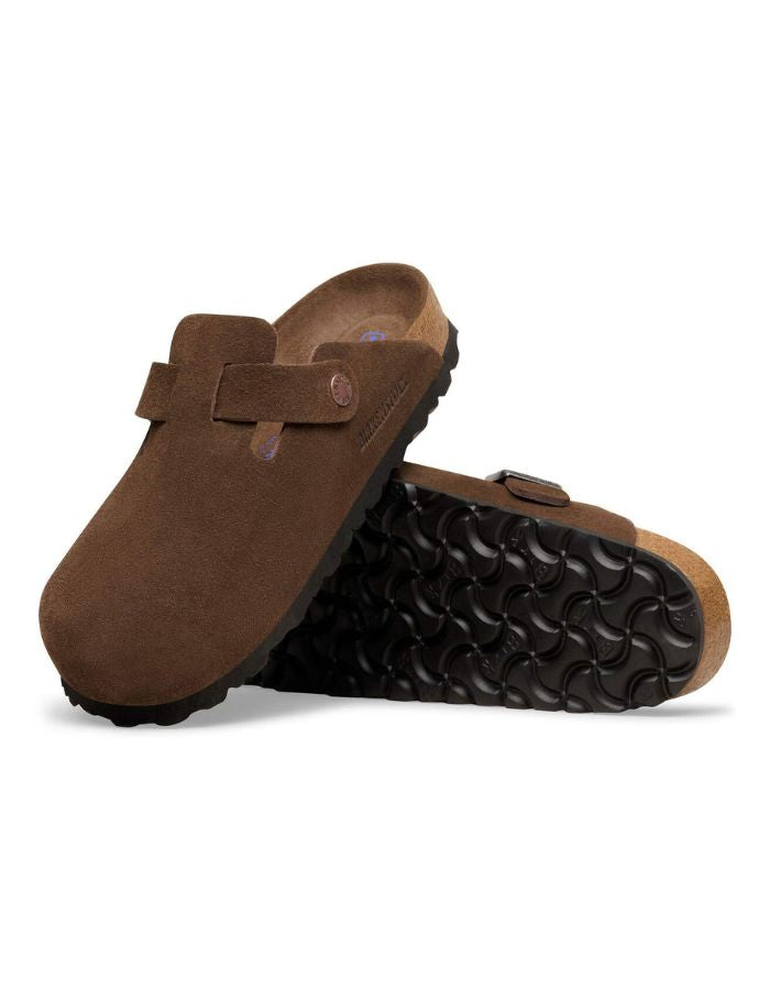Semelle des Sabots fermés modèle Boston de la marque Birkenstock en cuir velours souple de couleur marron foncé Carafe. Présente une bride ajustable à boucle métallique sur le dessus et une semelle anatomique ton sur ton en liège avec lit de pied souple, version chaussant étroit.