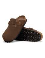 Semelle des Sabots fermés modèle Boston de la marque Birkenstock en cuir velours souple de couleur marron foncé Carafe. Présente une bride ajustable à boucle métallique sur le dessus et une semelle anatomique ton sur ton en liège avec lit de pied souple, version chaussant étroit.