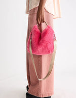 Sac Helcro rose géranium en fausse fourrure moelleuse, porté main avec bandoulière amovible.