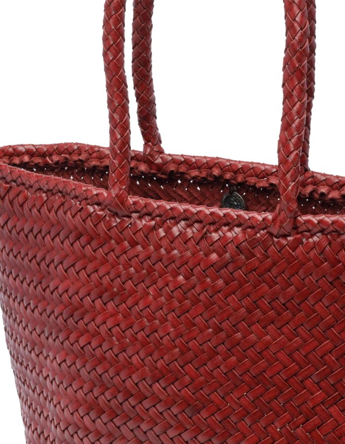 Vue du dessus du petit sac panier Grace Basket de Dragon Diffusion en cuir tressé bordeaux, forme arrondie galbée avec tissage en diagonale et poignées tressées.