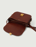 Sac Bellissima Mini Soeur en cuir caviar cognac, rabat ouvert révélant trois compartiments, fermoir monogramme doré.