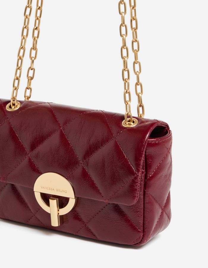 Chaîne du Moyen sac bandoulière pour femme en cuir de vachette craquelé bordeaux cerise avec fermoir rond doré et bandoulière chaîne, modèle Moyen Sac Moon Cuir Craquelé couleur Cerise de Vanessa Bruno.