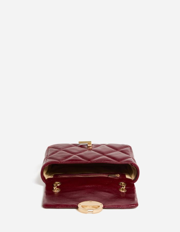 Ouverture du Moyen sac bandoulière pour femme en cuir de vachette craquelé bordeaux cerise avec fermoir rond doré et bandoulière chaîne, modèle Moyen Sac Moon Cuir Craquelé couleur Cerise de Vanessa Bruno.