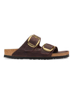 Vue de profil des Sandales Birkenstock modèle Arizona Big Buckle avec chaussant étroit. Présente deux larges brides en cuir huilé épais à bords bruts dotées de grandes boucles métalliques élégantes, montées sur la célèbre semelle anatomique en liège et cuir lisse assorti.