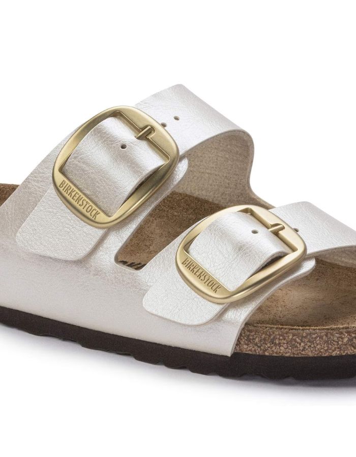 Boucle des Sandales Birkenstock Arizona Big Buckle en largeur étroite. Les deux brides réglables sont en Birko-Flor® blanc nacré satiné (Graceful Pearl White) avec de grandes boucles en métal argenté, reposant sur une semelle anatomique en liège et cuir velours.