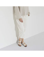 Vue de dessus des Sandales Birkenstock Arizona Big Buckle en largeur étroite. Les deux brides réglables sont en Birko-Flor® blanc nacré satiné (Graceful Pearl White) avec de grandes boucles en métal argenté, reposant sur une semelle anatomique en liège et cuir velours.