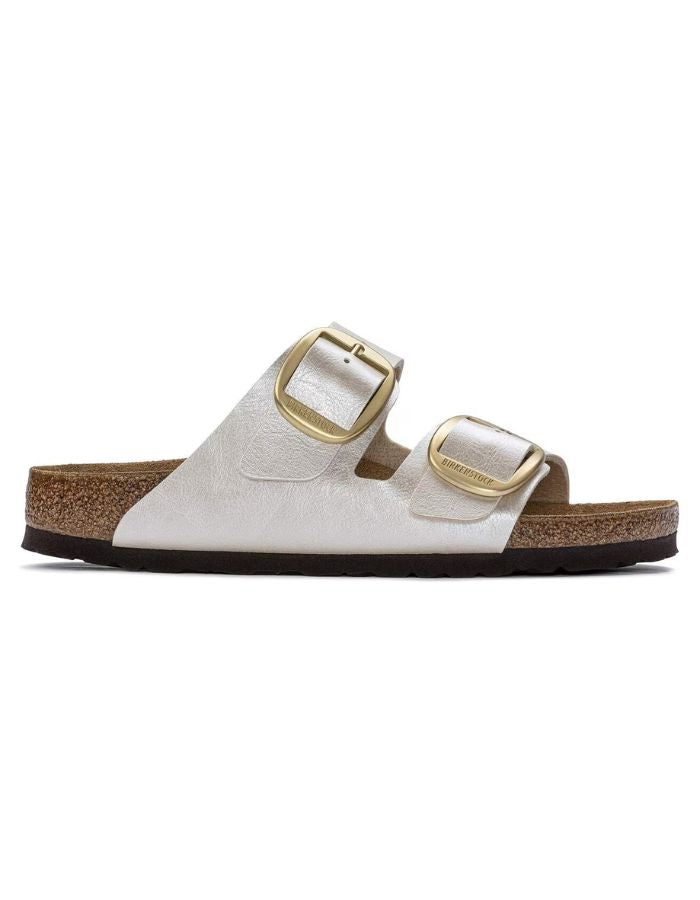 Profil des Sandales Birkenstock Arizona Big Buckle en largeur étroite. Les deux brides réglables sont en Birko-Flor® blanc nacré satiné (Graceful Pearl White) avec de grandes boucles en métal argenté, reposant sur une semelle anatomique en liège et cuir velours.